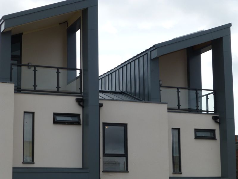 Contemporary balconies with glass balustrades inside steel surrounds