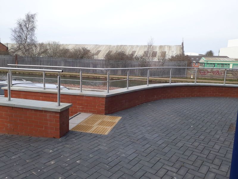 Steel balustrade fixed to a brick parapet around a roof terrace