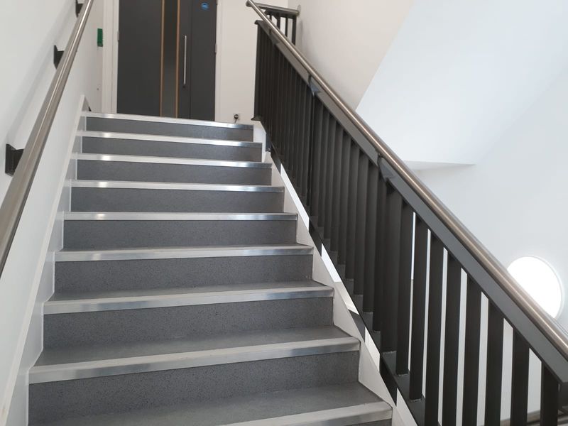 Steel spindle balustrade with a dark handrail on a stairwell