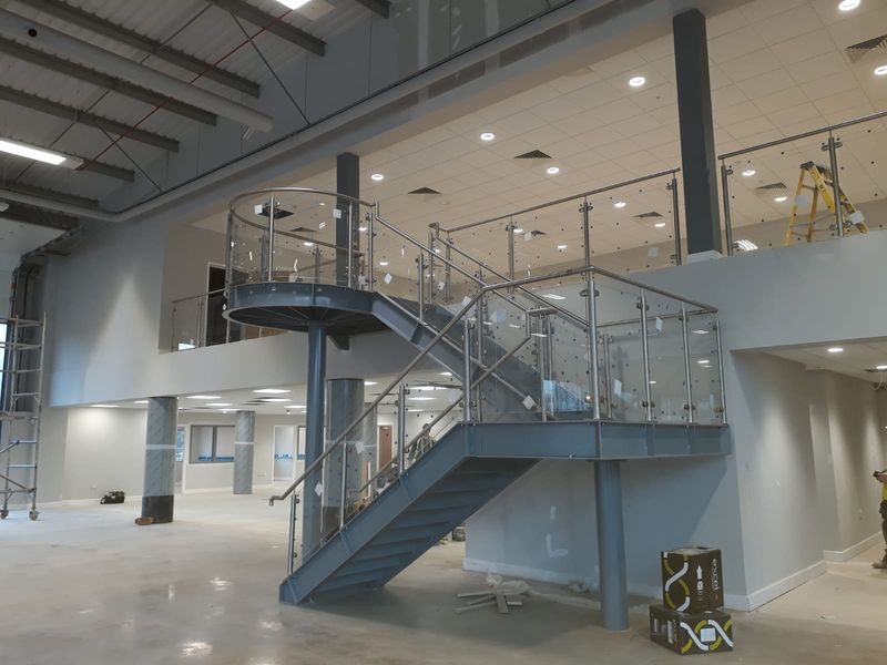 Glass balustrade with stainless steel posts and handrails on a staircase and mezzanine