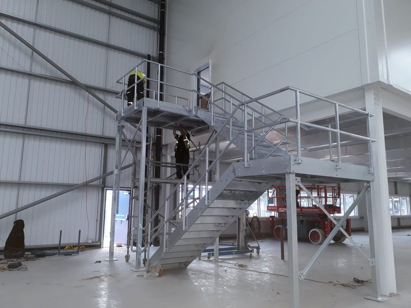 Galvanised steel stairs and landing being installed
